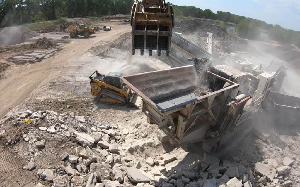 Crawler mobile impact crusher is crushing concrete blocks